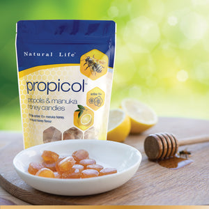 Natural Life Propicol - Propolis & Manuka Honey Candies stock photo with plate of candies, lemons and stick of honey
